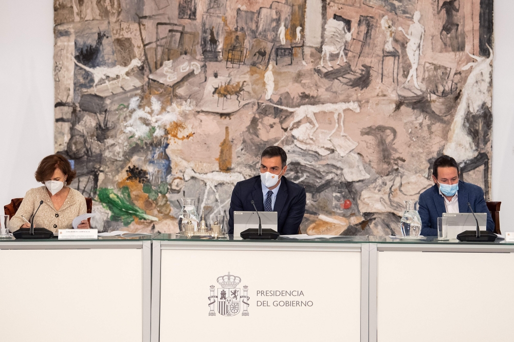 A handout picture released by the Moncloa Palace shows (L-R) Spain's Deputy Prime Minister and Minister of Presidency and Relations with Parliament Carmen Calvo, Spain's Prime Minister Pedro Sanchez and Spain's Deputy Prime Minister for Social Rights and 