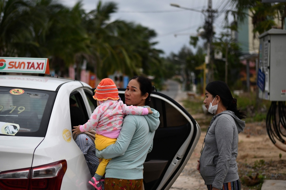 Residents get in a car after leaving their homes to move to evacuation centres in central Vietnam's Quang Nam province on October 27, 2020, ahead of Typhoon Molave's expected landfall. / AFP / MANAN VATSYAYANA