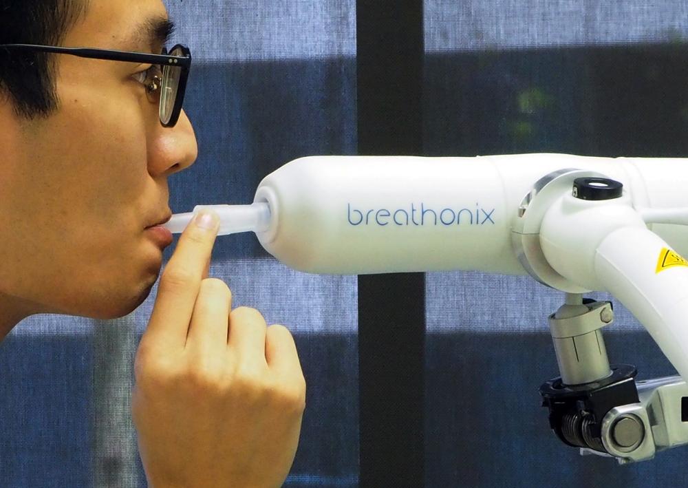 A staff member demonstrates the usage of Breathonix breathalyzer test kit developed by Breathonix, a start-up by the National University of Singapore, able to detect the coronavirus disease (COVID-19) within a minute according to the company, at their lab
