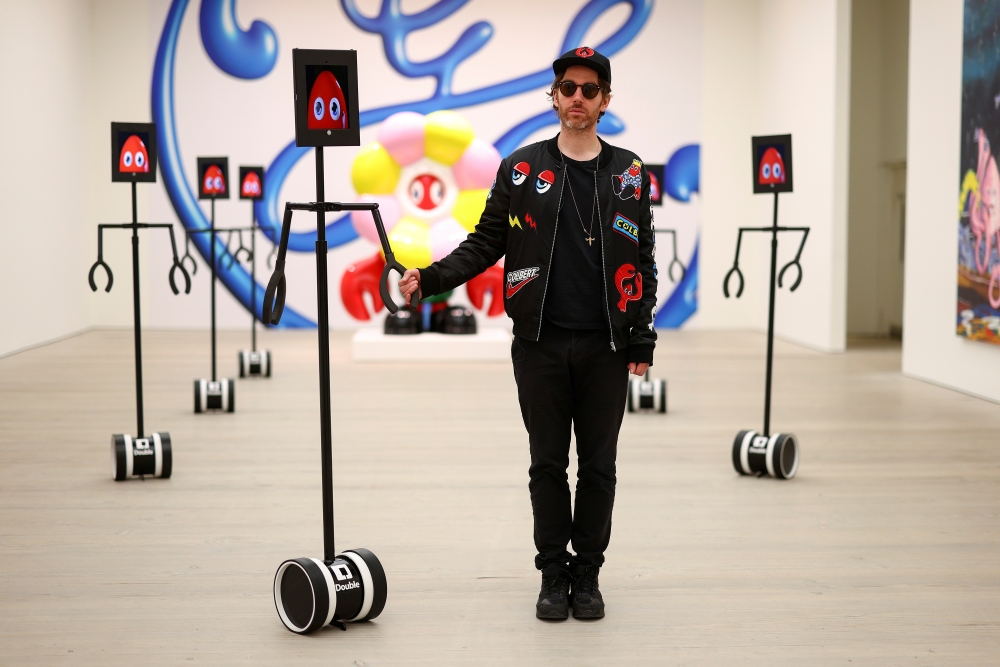 Philip Colbert poses for a photograph with robots that allow viewers to interactively engage with his Lobsteropolis exhibition at a preview event at the Saatchi Gallery in London, Britain, October 28, 2020. Picture taken October 28, 2020. REUTERS/Simon Da