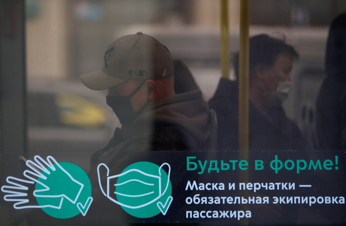 Passengers wear protective face masks in a bus amid the outbreak of the coronavirus disease (COVID-19) in Moscow, Russia October 29, 2020. A sign on a window reads: 