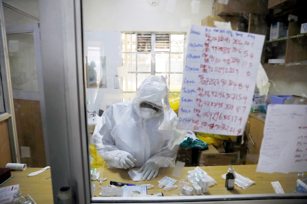 A member of the medical staff dressed in a protective suit prepares medicine for coronavirus disease patients inside the COVID-19 ICU of Machakos Level 5 Hospital, in Machakos, Kenya October 28, 2020. REUTERS/Baz Ratner/File Photo