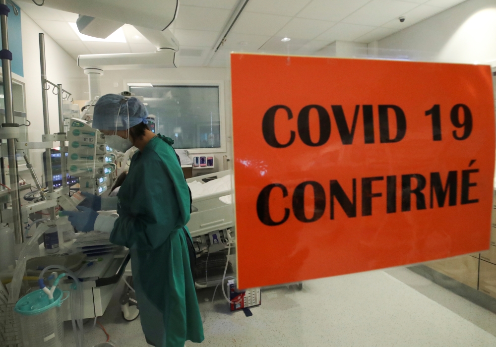 A health worker standing in an intensive care unit treats a patient suffering from the coronavirus disease (COVID-19), at Montlegia CHC clinic in Liege, Belgium October 29, 2020. REUTERS/Yves Herman
