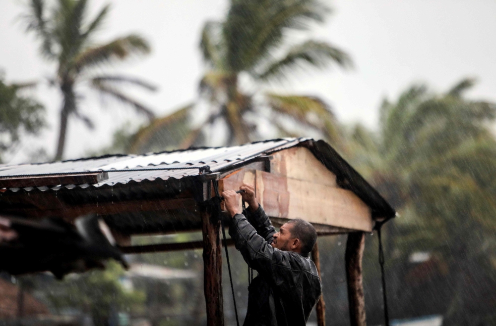 A man protects his beach house as Hurricane Eta approaches in Bilwi, Puerto Cabezas, Nicaragua, on November 2, 2020. Eta rapidly intensified to a Category 4 hurricane on Monday as it bore down on the Caribbean coast of Nicaragua and Honduras, threatening 