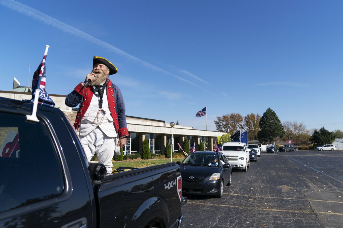 Trump supporter Matthew Woods, dressed as a Continental Army soldier, leads a Trump Train Rally on Election Day through the streets of Warren, Mich., Tuesday, Nov. 3, 2020. (AP Photo/David Goldman)