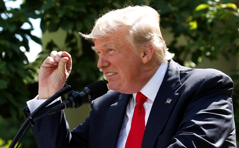 FILE PHOTO: U.S. President Donald Trump refers to amounts of temperature change as he announces his decision that the United States will withdraw from the landmark Paris Climate Agreement, in the Rose Garden of the White House in Washington, U.S., June 1,