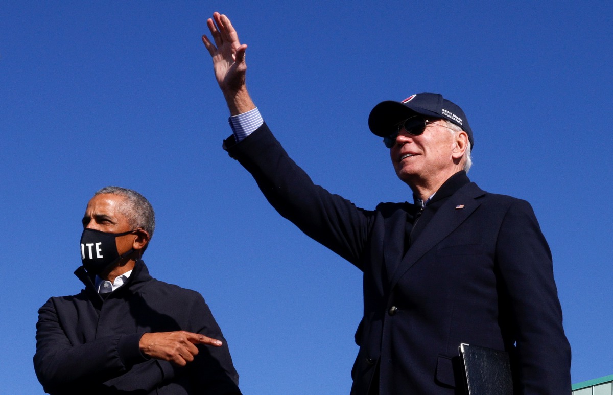 Democratic U.S. presidential nominee and former Vice President Joe Biden and former U.S. President Barack Obama gesture at a campaign drive-in, mobilization event in Flint, Michigan, U.S., October 31, 2020. REUTERS/Brian Snyder

