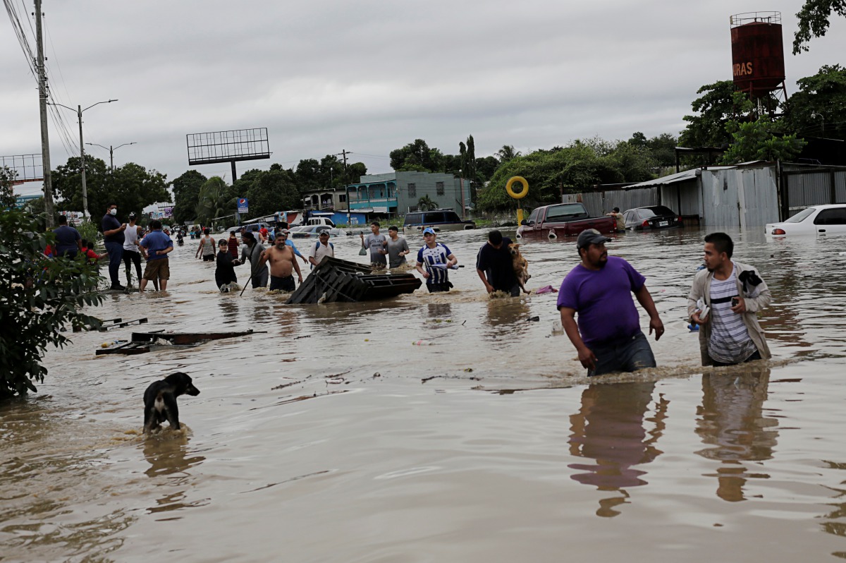 People walk through a flooded street during the passage of Storm Eta, in La Lima, Honduras November 5, 2020. REUTERS/Jorge Cabrera
