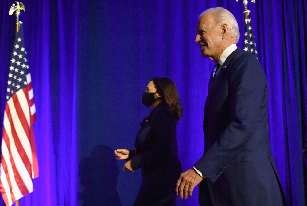 Democratic presidential nominee Joe Biden and Democratic vice presidential nominee Senator Kamala Harris walk off stage after Joe Biden delivered remarks at the Chase Center in Wilmington, Delaware, on November 6, 2020.   AFP / Angela Weiss