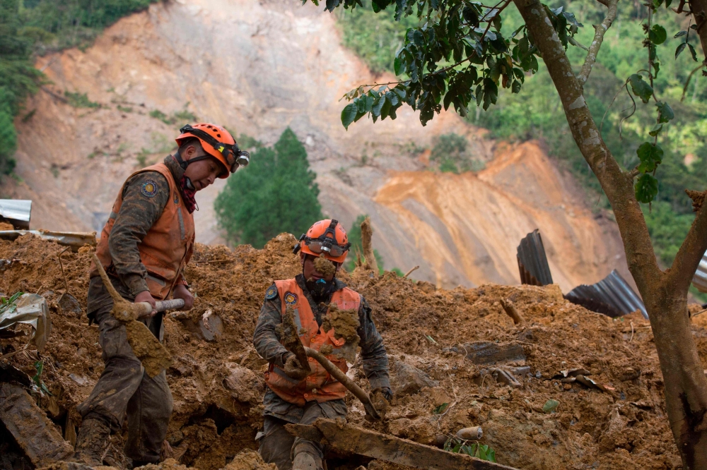 Rescue workers search for victims of a musdlide caused by the passage of Hurricane Eta in the village of Queja, in San Cristobal Verapaz, Guatemala on November 7, 2020. / AFP / POOL / Esteban BIBA