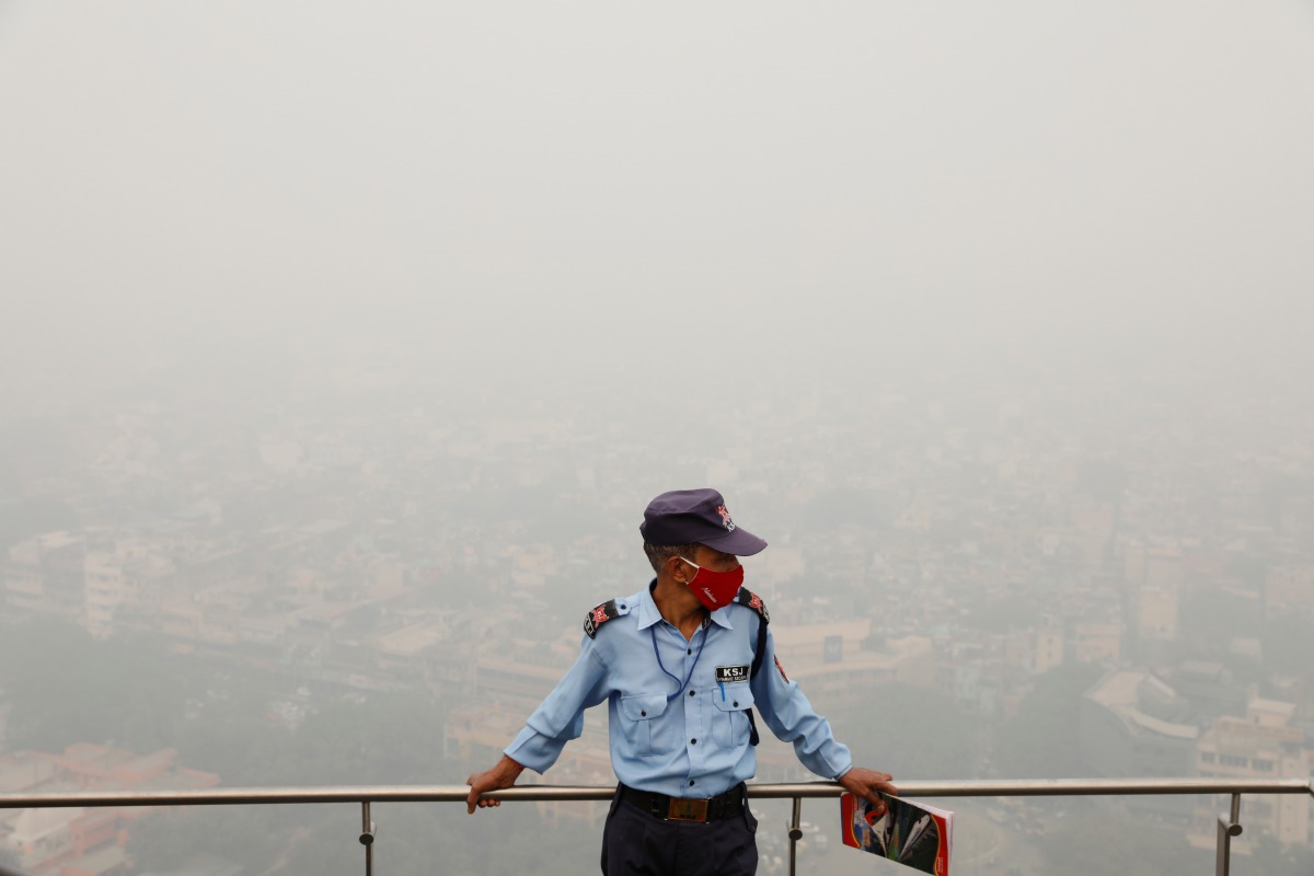 A security guard stands on top of a building amidst heavy smog in New Delhi, India, November 4, 2020. REUTERS/Adnan Abidi

