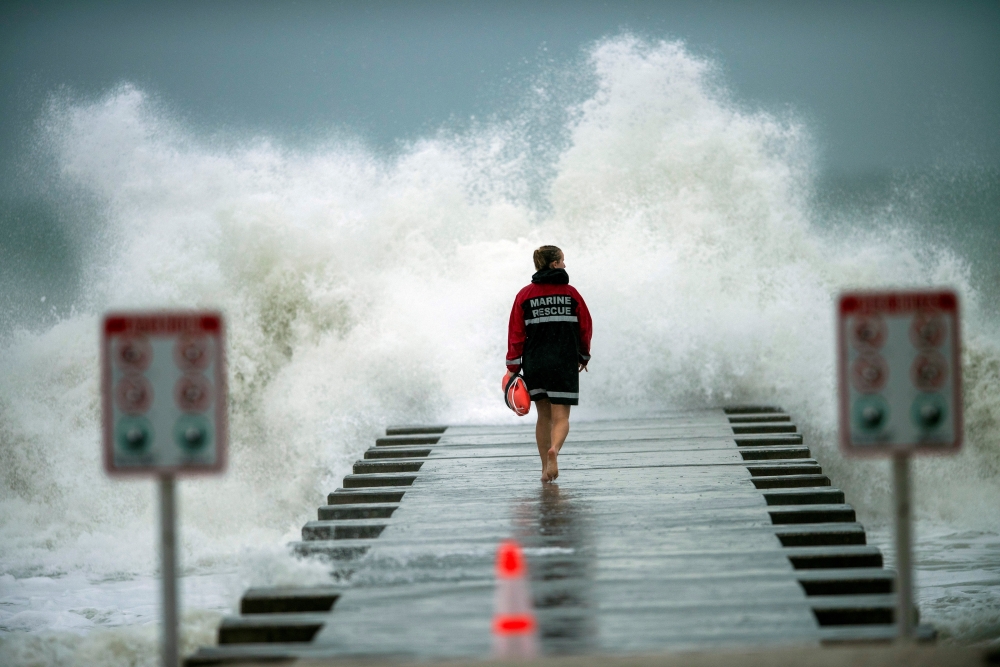 A lifeguard walks to the end of the jetty after closing it down to surfers before the arrival of Tropical Storm Eta in Bradenton Beach, Florida, U.S. November 11, 2020. REUTERS/Steve Nesius/File Photo