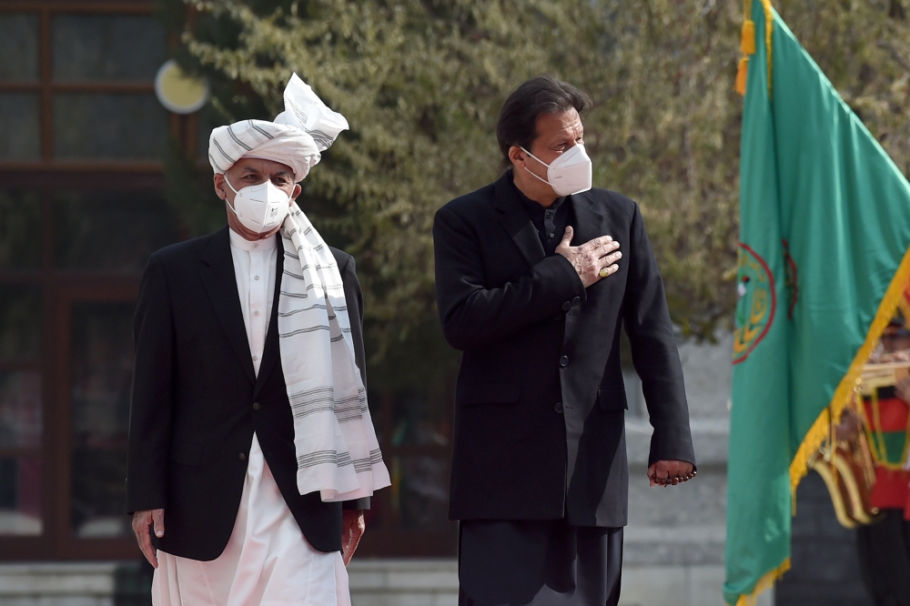 Pakistan's Prime Minister Imran Khan (R) and Afghan President Ashraf Ghani inspect a guard of honour ahead of their joint press conference at the Presidential Palace in Kabul on November 19, 2020. / AFP / WAKIL KOHSAR