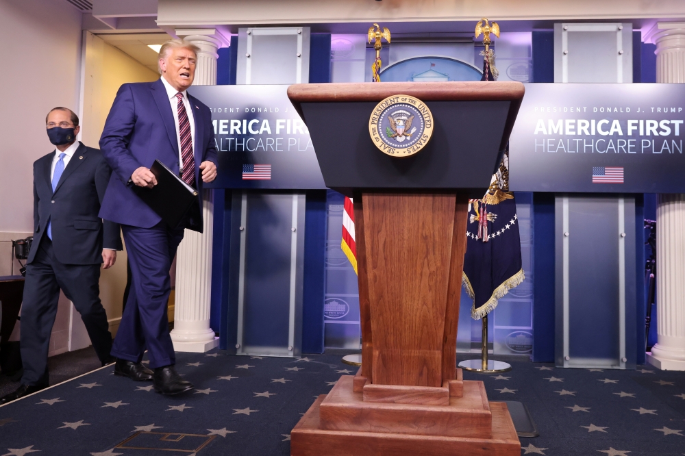 U.S. President Donald Trump is followed by Health and Human Services (HHS) Secretary Alex Azar as he arrives to speak about prescription drug prices in the Brady Press Briefing Room at the White House in Washington, U.S., November 20, 2020. REUTERS/Carlos
