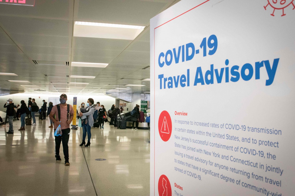 Travelers wait for their luggage at Newark International Airport on November 21, 2020 in Newark, New Jersey. Current US numbers -- more than a quarter of a million deaths have been reported -- have alarmed authorities enough to advise that people stay hom
