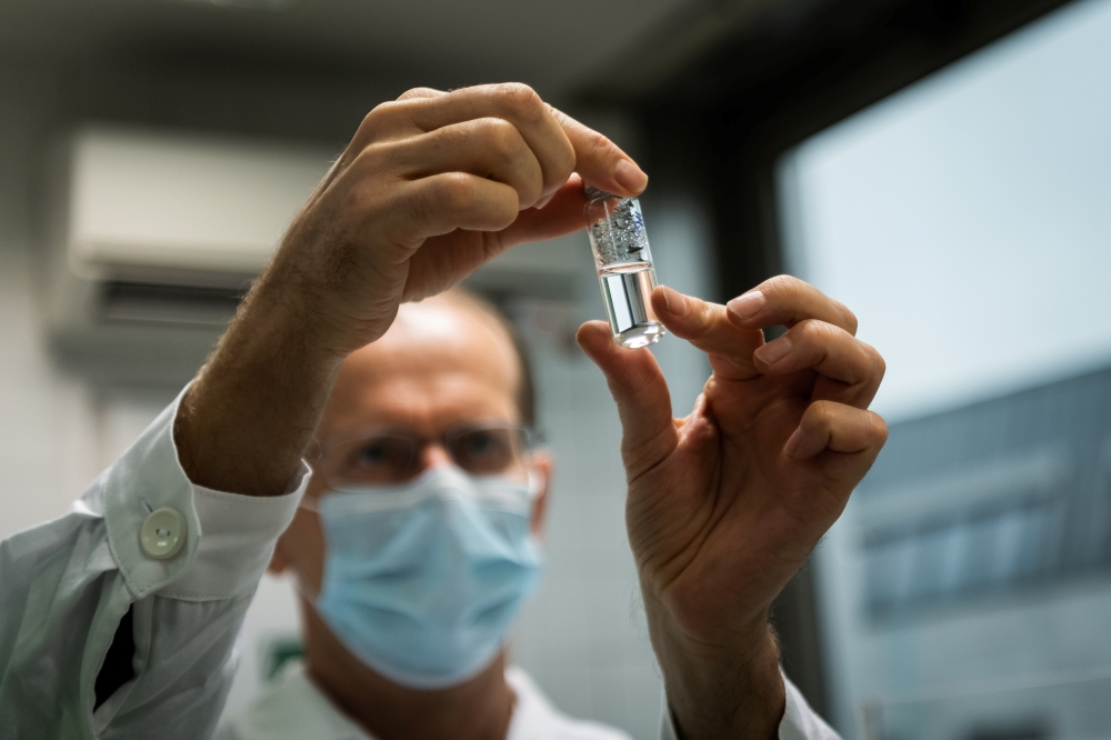 A laboratory assistant holds a tube with Russia's 