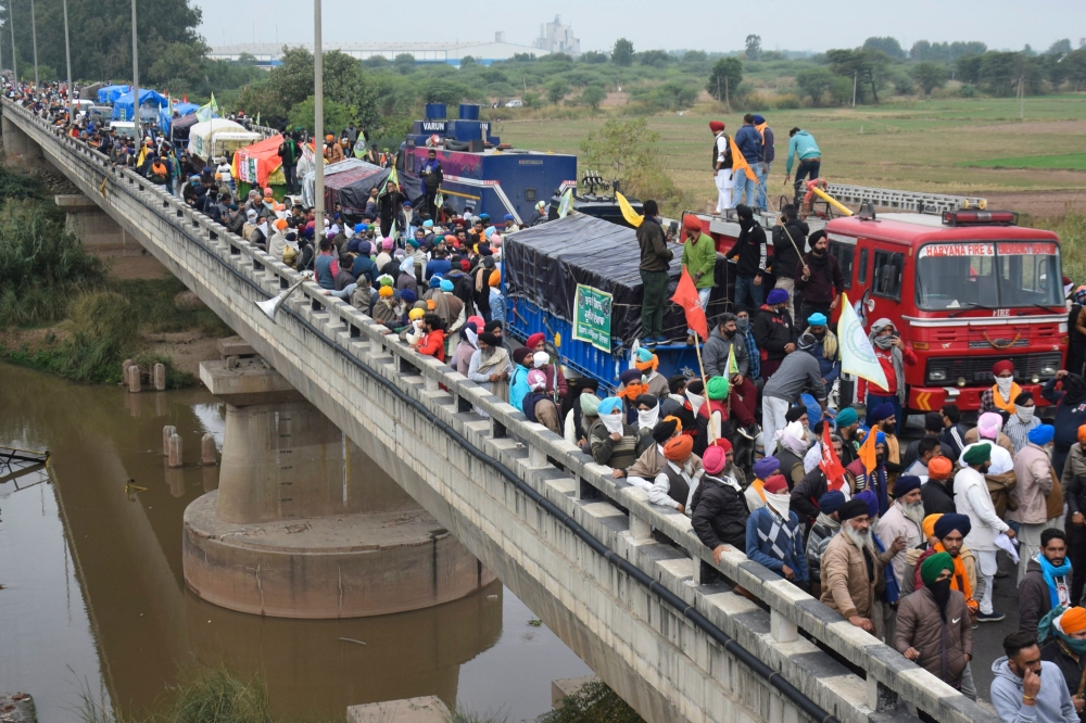 Farmers gather on a bridge as police block a road during a march to India's capital New Delhi to protest against the central government's recent agricultural reforms, on the outskirts of Ambala on November 26, 2020. AFP 