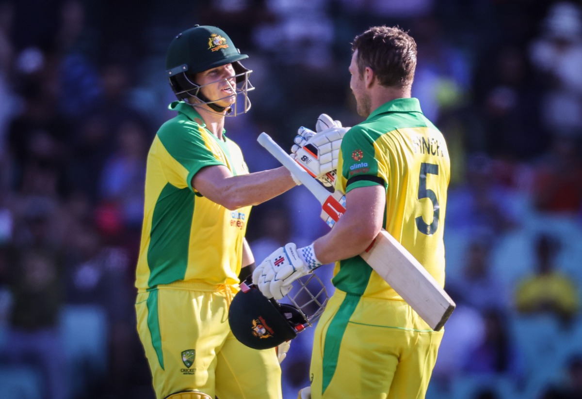 Australia's captain Aaron Finch (R) celebrates reaching his century with teammate Steve Smith during the one-day international cricket match against India at the Sydney Cricket Ground (SCG) in Sydney on November 27, 2020. / AFP / DAVID GRAY /