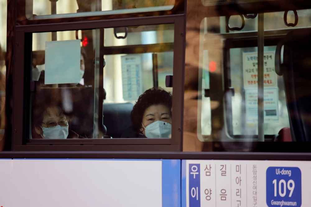 A woman wearing a face mask sits in a bus amid the coronavirus disease (COVID-19) pandemic in Seoul, South Korea, November 27, 2020. REUTERS/Heo Ran
