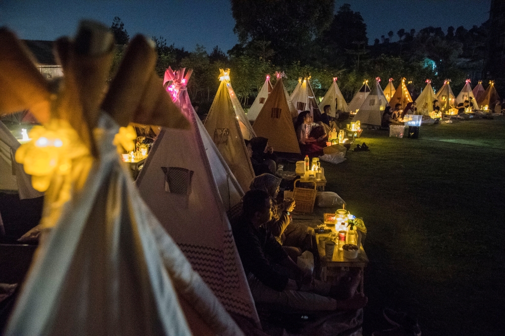 People watch movies from tents placed for social distancing at the campsites in Bandung, West Java Province, Indonesia, November 4, 2020. Picture taken November 4, 2020, in this photo taken by Antara Foto/M Agung Rajasa via Reuters