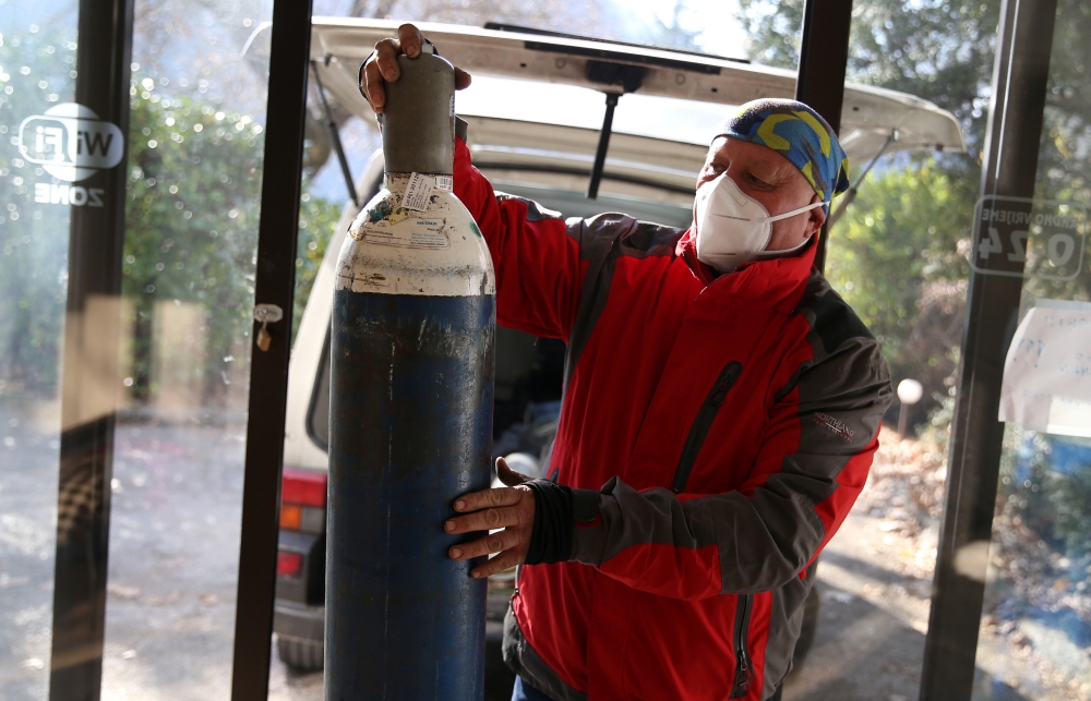 Miralem Sabic carries oxygen bottles from his private van to an improvised coronavirus disease (COVID-19) hospital in Konjic, Bosnia and Herzegovina, November 27, 2020. Picture taken November 27, 2020. REUTERS/Dado Ruvic