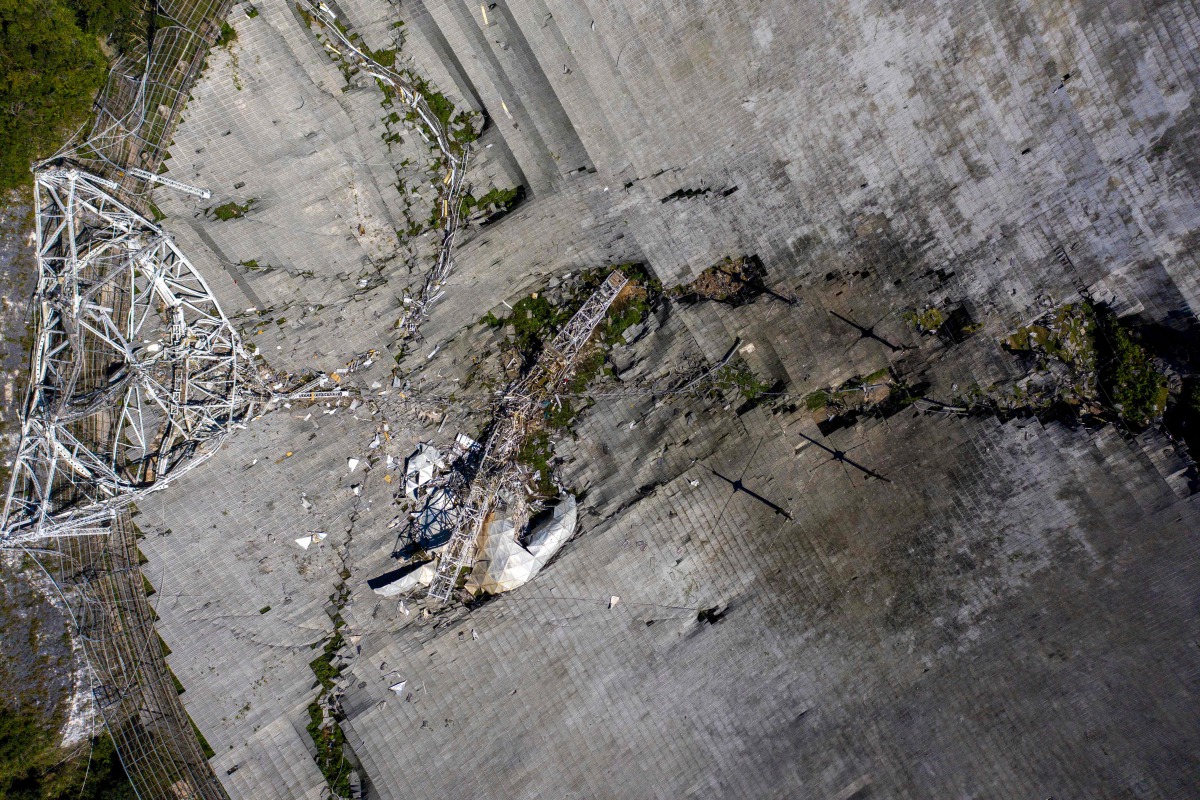 This aerial view shows the damage at the Arecibo Observatory after one of the main cables holding the reciever broke in Arecibo, Puerto Rico, on December 1, 2020. The radio telescope in Puerto Rico, which once starred in a James Bond film, collapsed Tuesd