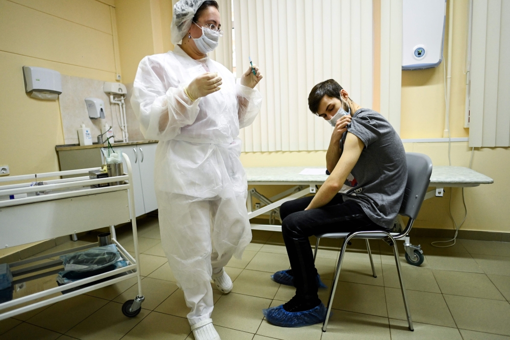 A nurse wearing a face mask proceeds to a vaccination against the coronavirus disease by Sputnik V (Gam-COVID-Vac) vaccine at a clinic in Moscow on December 5, 2020. AFP / Kirill Kudryavtsev 