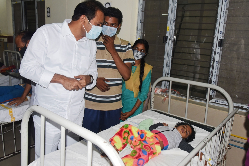 In this handout photo take and released by the Public Relations Department Government of Andhra Pradesh on December 6, 2020, Andhra Pradesh Health minister Alla Nani (L) visits patients receiving medical care for a mystery illness at a government hospital
