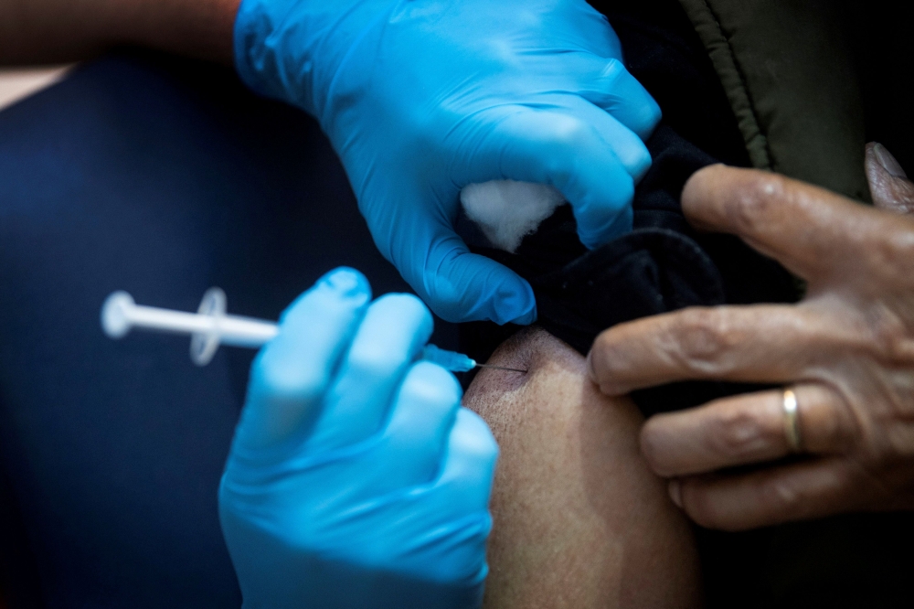 A man receives the first of two Pfizer/BioNTech COVID-19 vaccine jabs, at Guy's Hospital, at the start of the largest-ever immunisation programme in British history, in London, Britain December 8, 2020. Victoria Jones/Pool via Reuters/File Photo