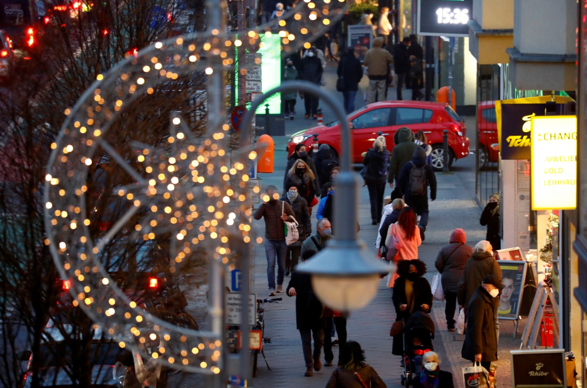 People with protective face masks walk beside Christmas themed lights at Schloss Strasse shopping street, amid the coronavirus disease (COVID-19) outbreak in Berlin, Germany, December 10, 2020. REUTERS/Fabrizio Bensch
