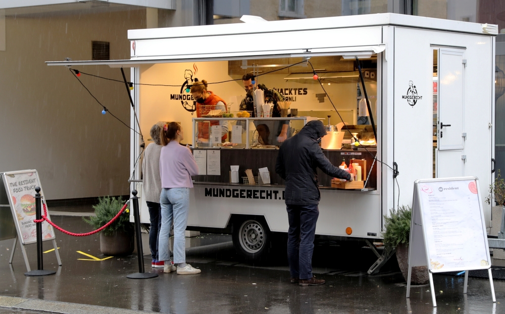People stand in front The Resident Food Truck snack stall, as the spread of the coronavirus disease (COVID-19) continues, in Zurich, Switzerland December 9, 2020. REUTERS/Arnd Wiegmann