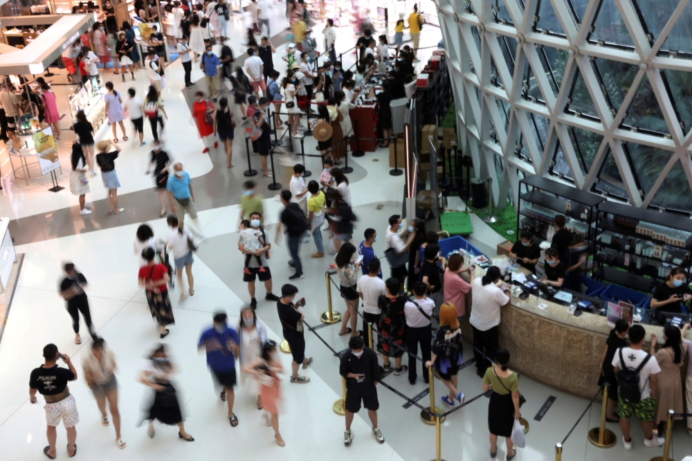 People wearing face masks following the coronavirus disease (COVID-19) outbreak shop at the Sanya International Duty-Free Shopping Complex in Sanya, Hainan province, China November 25, 2020. REUTERS/Tingshu Wang/File Photo
