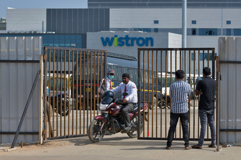 People exit from the gate of Wistron, a Taiwanese-run iPhone factory at Narsapura, about 60 km from Bangalore on December 13, 2020. AFP / Manjunath Kiran
