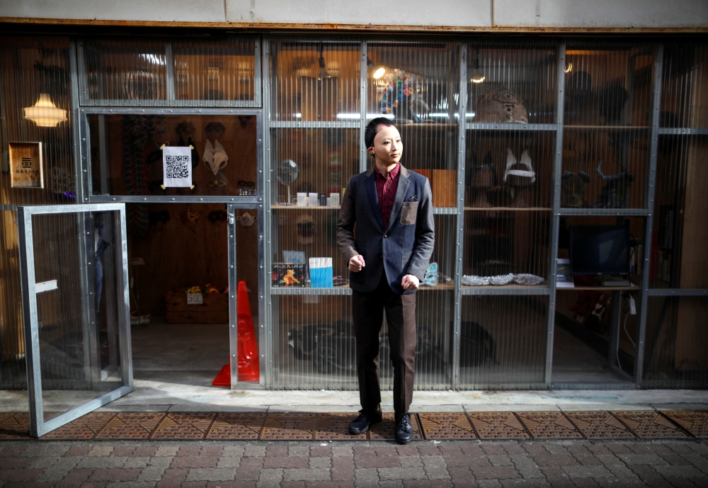 Shuhei Okawara, 30, owner of mask shop Kamenya Omote, wears a face mask based on a real person's face as he stands in front of his shop in Tokyo, Japan December 16, 2020. REUTERS/Issei Kato