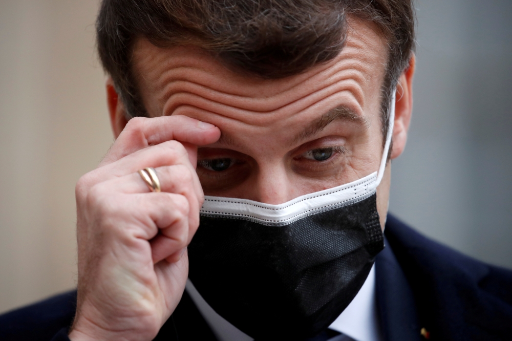 French President Emmanuel Macron, wearing a protective face mask, scratches his brow as he talks to the media next to Portugal's Prime Minister Antonio Costa (not seen) before a meeting at the Elysee Palace in Paris, France, December 16, 2020. REUTERS/Gon