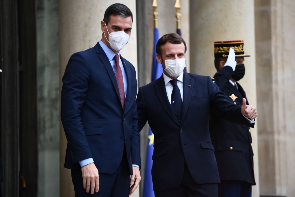 In this file photo taken on December 14, 2020 French President Emmanuel Macron (R) welcomes Spanish Prime minister Pedro Sanchez prior to a meeting marking the 60th anniversary of the creation of the Organisation for Economic Co-operation and Development 