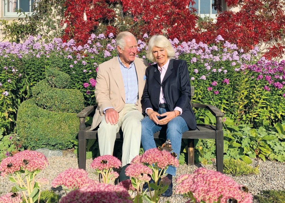 This undated handout picture released by Clarence House on December 16, 2020, shows Britain's Prince Charles, Prince of Wales (L) and Britain's Camilla, Duchess of Cornwall posing for their 2020 Christmas card at Birkhall in Aberdeenshire, Scotland. / AFP