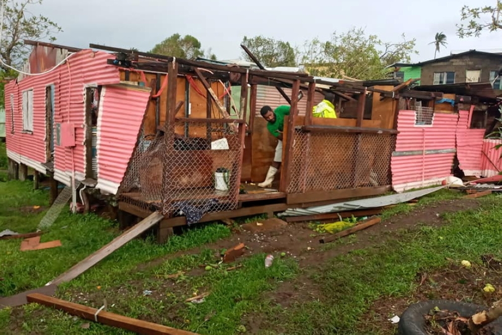 A man works on a damaged house in the aftermath of Cyclone Yasa in Nasavu, Bua Province, Fiji December 18, 2020, in this image obtained from social media. Miriama Nakauvadra/via Reuters 