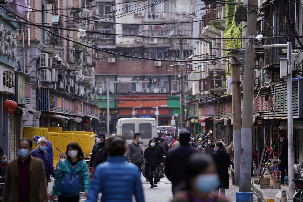 People wearing face masks walk on a street market in Wuhan, Hubei province, the epicentre of China's novel coronavirus disease (COVID-19) outbreak, April 6, 2020. RUETERS/Aly Song/File Photo