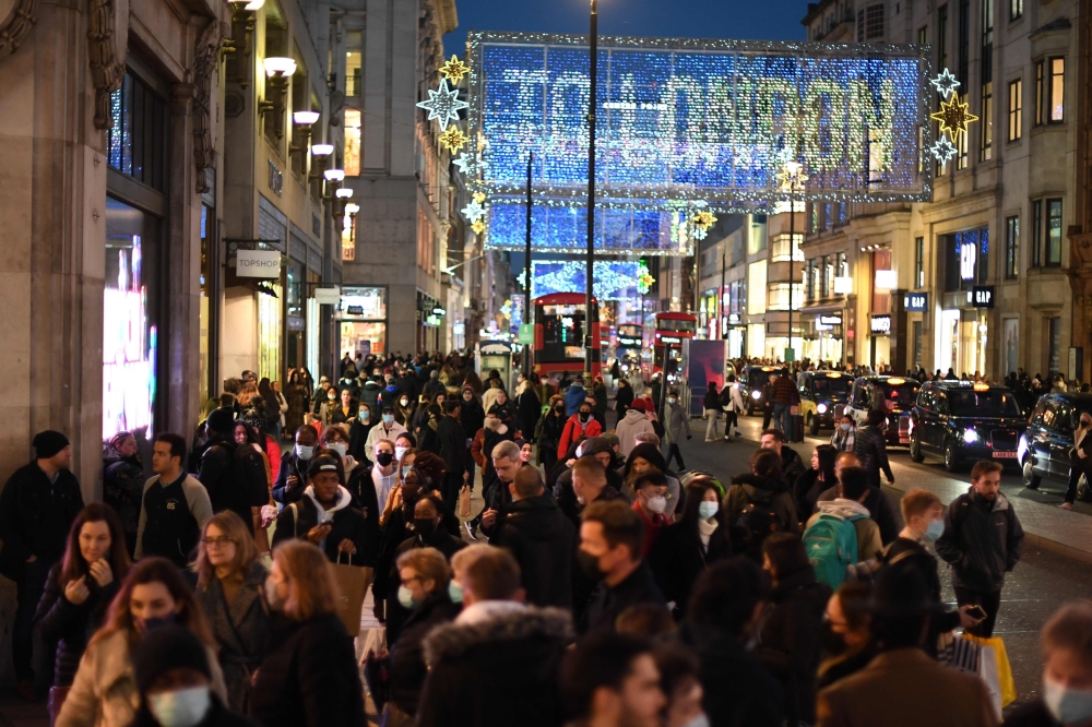 Christmas illuminations are seen above shoppers on Regent Street in the main high-street shopping area of London on December 15, 2020 ahead of fresh measures for the capital amid rising novel coronavirus infection rates. AFP / DANIEL LEAL-OLIVAS