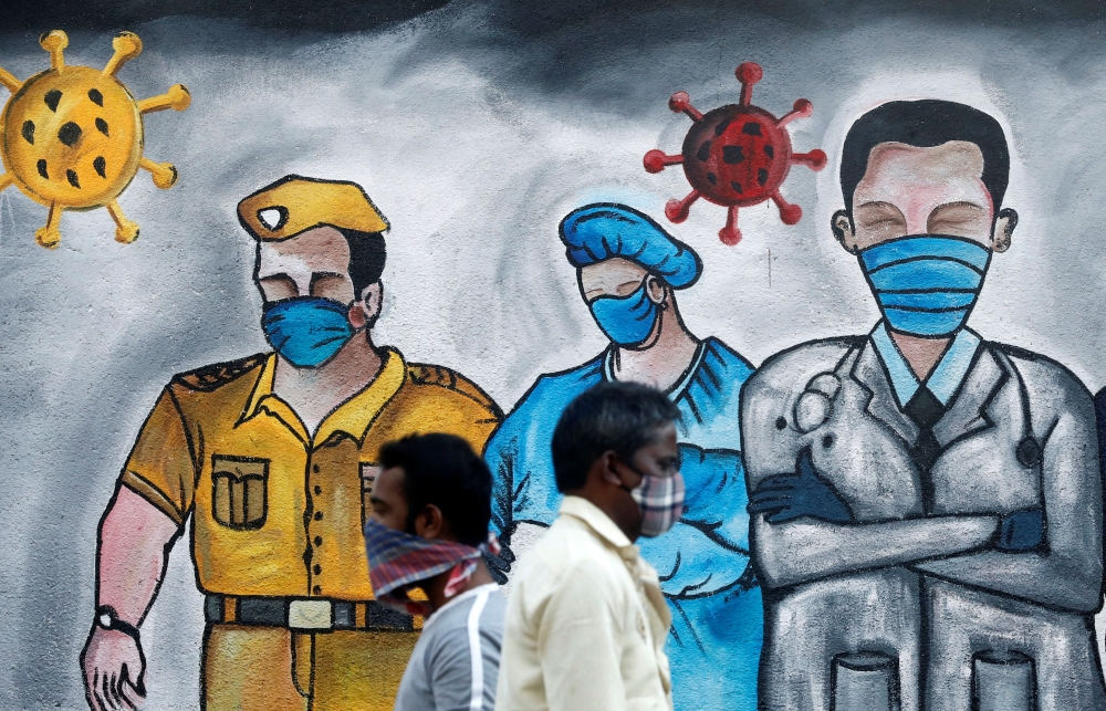 Men walk past a mural of frontline workers amid the spread of the coronavirus disease (COVID-19), in Mumbai, India, December 21, 2020. REUTERS/Francis Mascarenhas