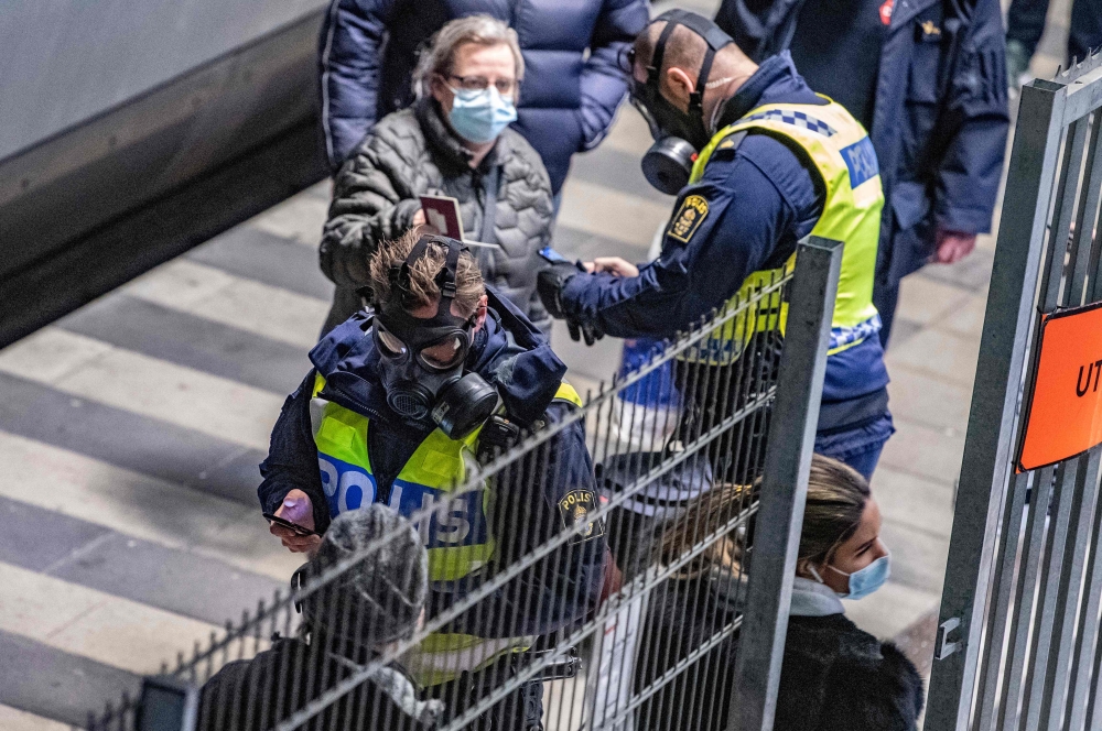 Travellers from Denmark are controlled by Swedish police wearing protective masks at the border control point at Hyllie station on Decmber 22, 2020.  Sweden OUT / AFP / TT News Agency / Johan NILSSON
