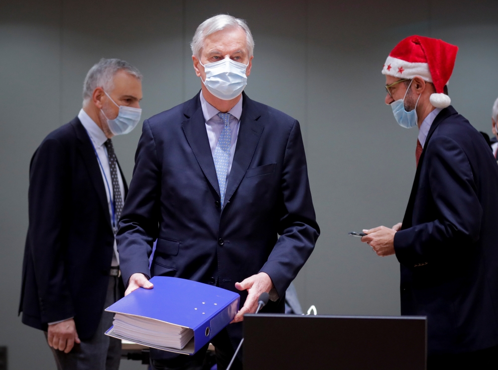 European Union's chief Brexit negotiator Michel Barnier holds the pages of the Brexit trade deal as he attends a meeting of the Committee of the Permanent Representatives of the Governments of the Member States to the European Union in Brussels, Belgium D