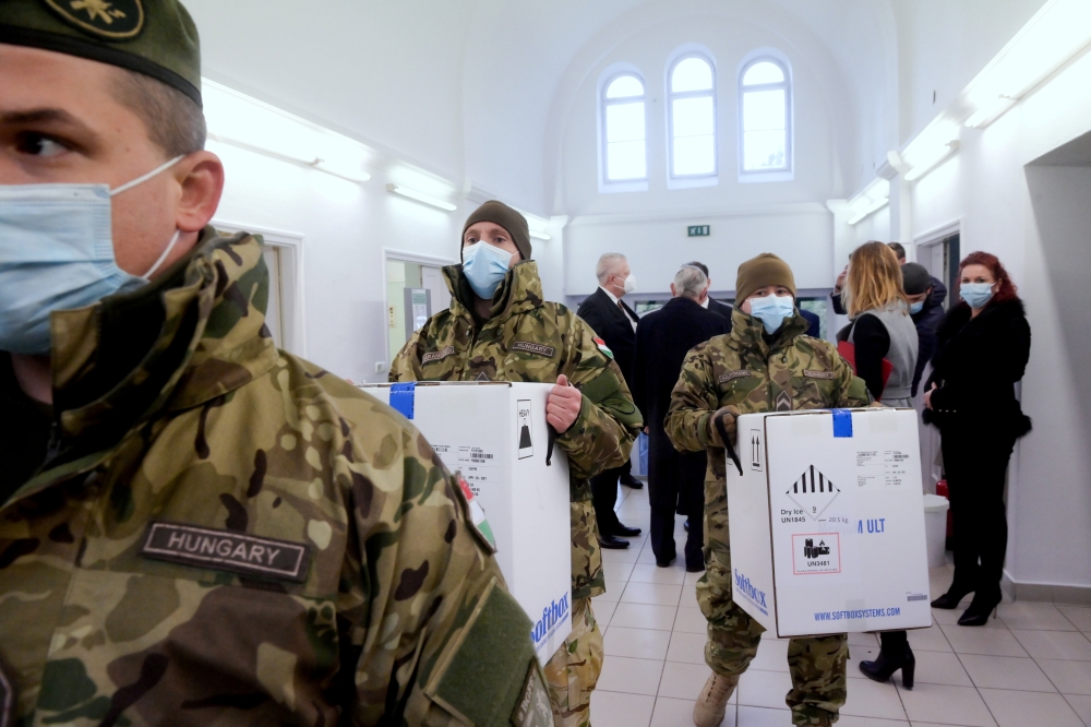 Hungarian soldiers carry the first shipment of Pfizer-BioNTech coronavirus disease (COVID-19) vaccines at the Del-Pest Central Hospital in Budapest, Hungary, December 26, 2020. Szilard Koszticsak/Pool via REUTERS