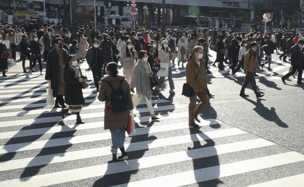 Passersby wearing protective face masks walk on the Shibuya crossing, amid the coronavirus disease (COVID-19) outbreak in Tokyo, Japan, in this photo taken by Kyodo December 26, 2020. Kyodo/via Reuters