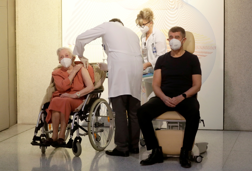World War II veteran Emilie Repikova sits next to PM Andrej Babis as she receives the second injection nationwide with a dose of Pfizer-BioNTech COVID-19 vaccine at Military University Hospital, as the coronavirus disease (COVID-19) outbreak continues, in