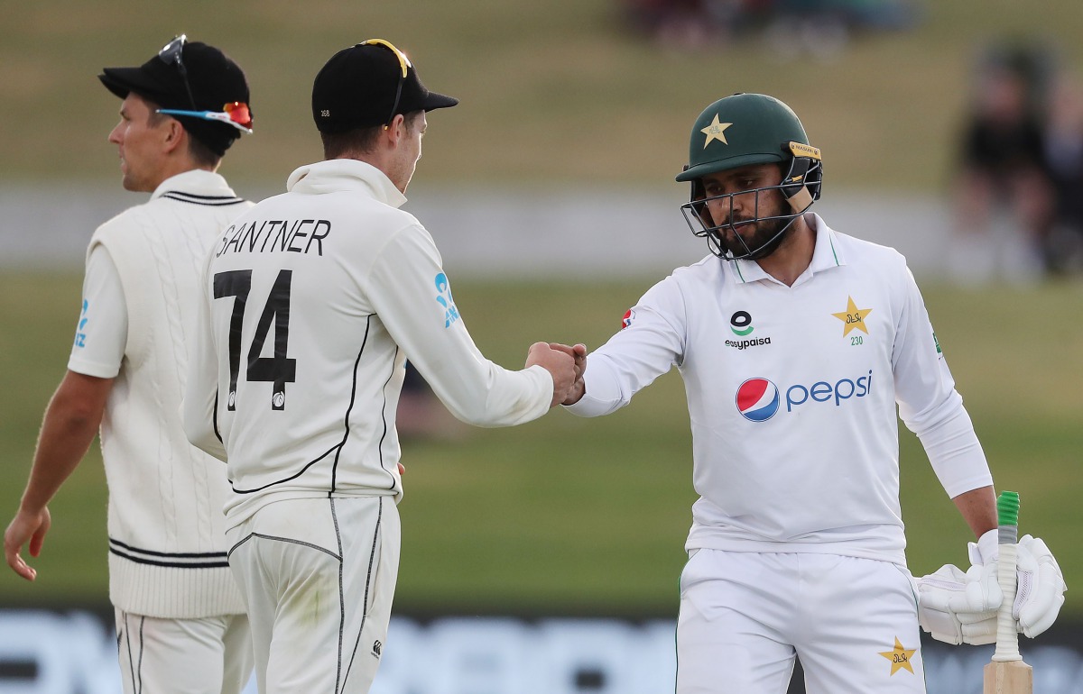 Pakistan’s Faheem Ashraf touches fist with New Zealand’s Mitchell Santner (2nd L) on day three of the first cricket Test match between New Zealand and Pakistan at the Bay Oval in Mount Maunganui on December 28, 2020. / AFP / MICHAEL BRADLEY
