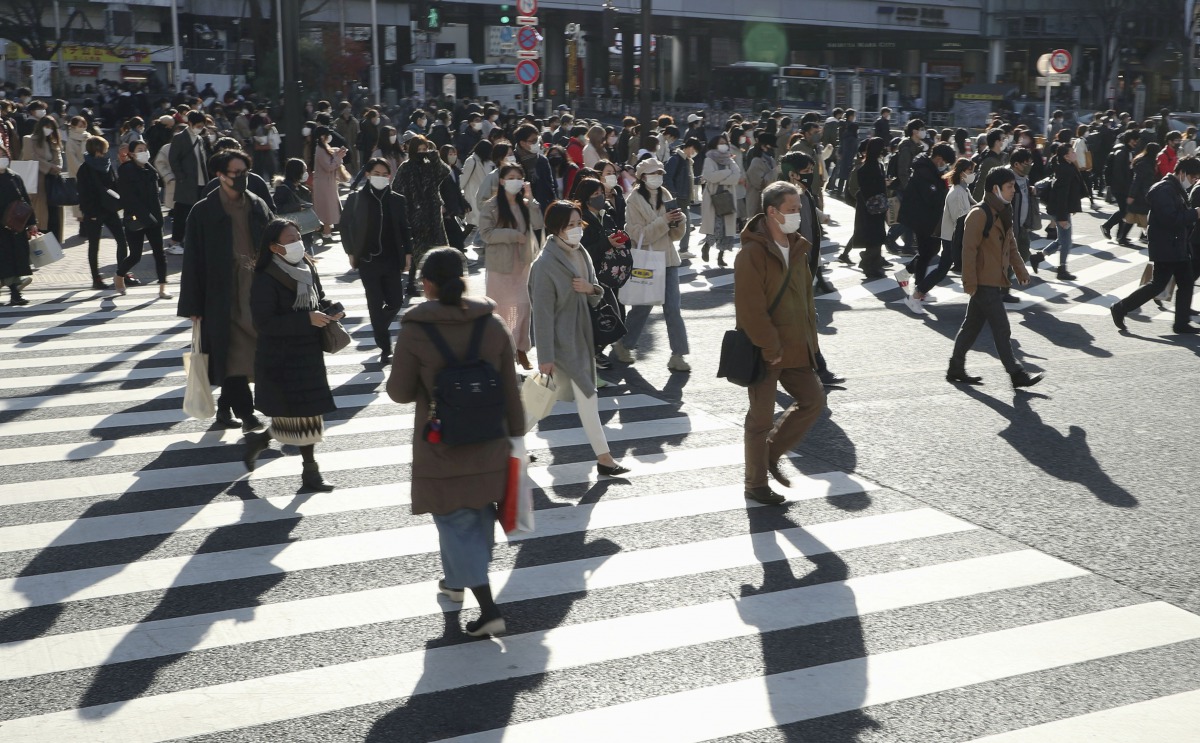 Passersby wearing protective face masks walk on the Shibuya crossing, amid the coronavirus disease (COVID-19) outbreak in Tokyo, Japan, in this photo taken by Kyodo December 26, 2020. Mandatory credit Kyodo/via REUTERS