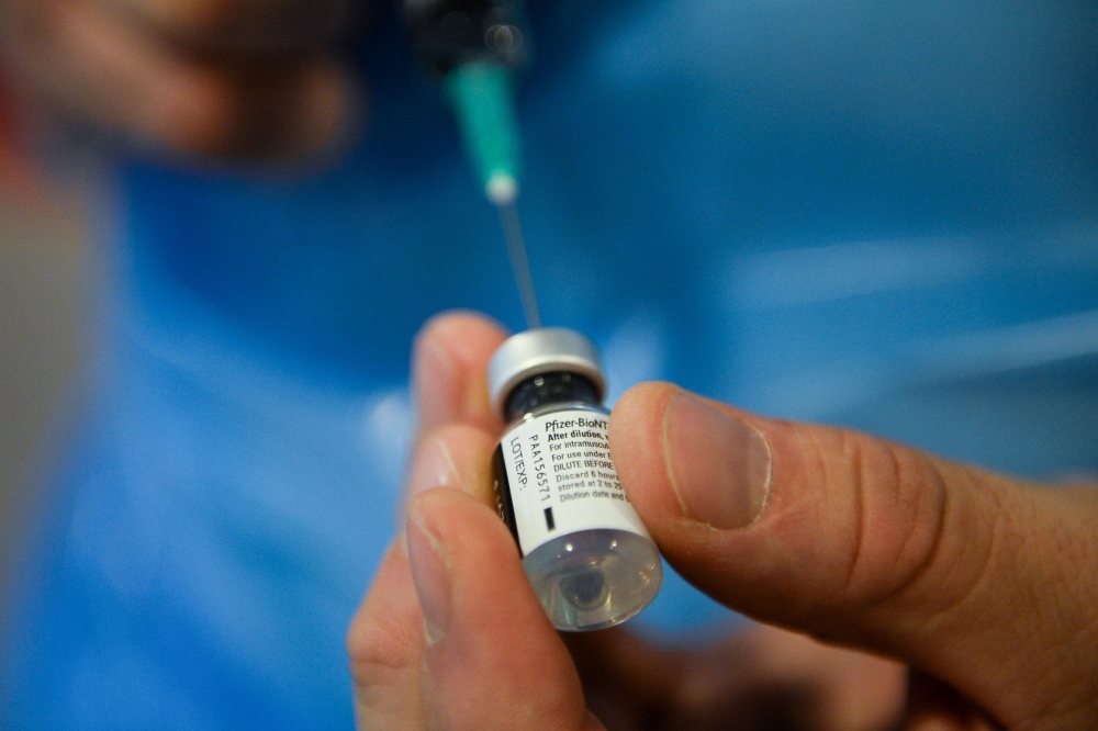 A member of the medical staff prepares a dose of the Pfizer/BioNtech COVID-19 vaccine at the Notre-Dame hospital in Brussels, for Belgian patient Lucie Danjou, 101, on December 28, 2020 as the country starts its national vaccination campaign to fight agai