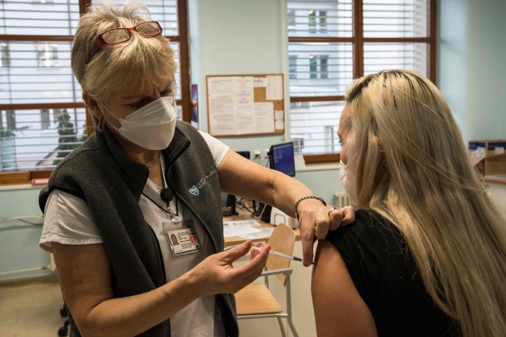 Medical staff is being innoculated with a dose of Pfizer-BioNTech COVID-19 vaccine at the University Hospital in Prague, on December 27, 2020. AFP / Michal Cizek